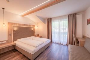 a bedroom with a bed and a large window at Hotel Christine in Gargazzone +58 photos