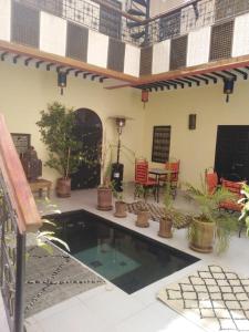 d'un patio avec une piscine agrémentée de plantes en pot dans l'établissement Riad JEREMY, à Marrakech
