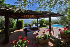 a wooden pergola with a bench and a swimming pool at Casa Citille in Greve in Chianti
