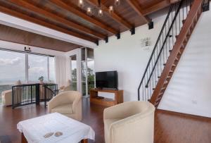 a living room with a staircase and a tv and chairs at Harrington Heritage in Hatton