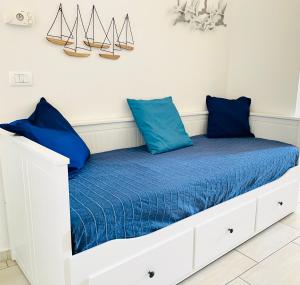 uma cama branca com almofadas azuis em CASA GIO'-vista mare,tribunale e castello nel pieno CENTRO di Trani-WIFI em Trani