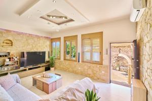 un soggiorno con divano e TV di Villa Vlite a Souda (Suda)