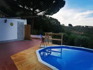 a blue swimming pool on a wooden deck next to a house at L'Opuntia sul lago in Caccamo