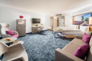 ein Hotelzimmer mit einem Bett und einem Wohnzimmer in der Unterkunft Hotel Celler Tor in Celle