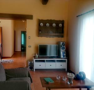 uma sala de estar com uma televisão de ecrã plano e colunas em L'Opuntia sul lago em Caccamo