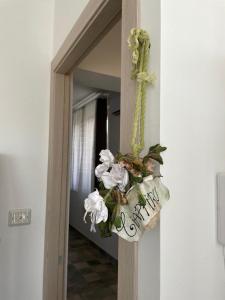 a door with a flower arrangement on the wall at Bàcula Nzícula Marzamemi in Marzamemi