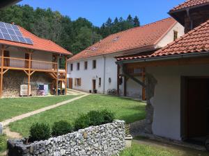 uma casa com uma parede de pedra e uma casa com um telhado solar em Zevlův mlýn em Nové Hrady