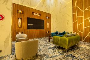 فندق وايت ديموند - النزهة في جدة: غرفة معيشة مع كرسيين وتلفزيون