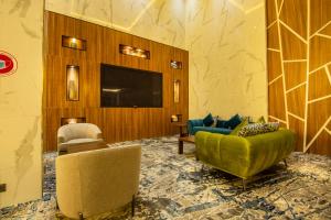 a living room with two chairs and a television at White Diamond Hotel - Al Nuzha in Jeddah