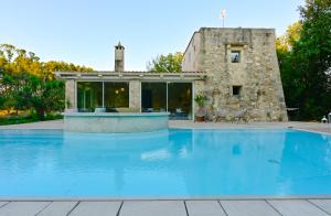 a pool in front of a stone house at Tenuta i rosoni in Cursi