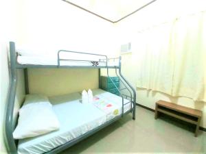 um quarto de hospital com um beliche e um banco em Gaea's Apartments em Panglao