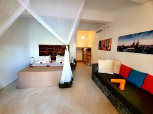 ジャンビアニにあるCasa Beach Hotel "Casa Del Mar"のベッドルーム(大型ベッド1台、ソファ付)