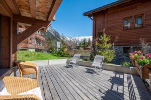 a wooden deck with chairs and a house at AUx SPORTS D HIVER in Courchevel