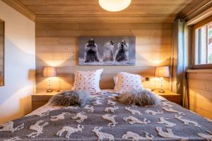 a bedroom with a bed with two dogs on it at AUx SPORTS D HIVER in Courchevel