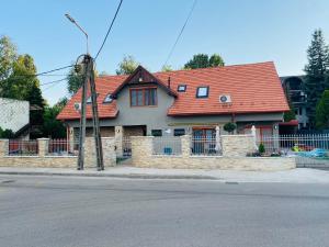 a house with a red roof on a street at Linton Apartmanház - Siófok, Plázs in Siófok