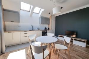 a kitchen and dining room with a table and chairs at Apartamenty przy Winnicy in Busko-Zdrój