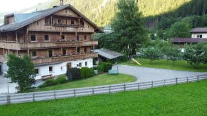 een groot houten huis met een hek ervoor bij Landhaus Eberler in Mayrhofen