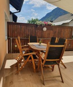 einen Holztisch und Stühle auf einer Terrasse in der Unterkunft Apartma Kreda in Mojstrana