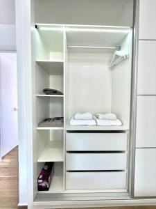 ein weißer Schrank mit weißen Regalen und Handtüchern in der Unterkunft Holiday Valley Fortuna in Adeje + 53 Fotos