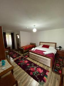 Guesthouse Mehmeti في فالبني: غرفة نوم بسرير كبير وسجادة كبيرة