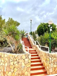 a set of stairs with a stone wall and palm trees at Holiday Valley Fortuna in Adeje