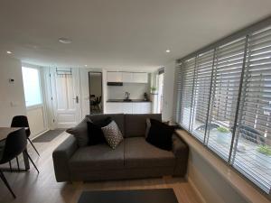 a living room with a couch and a large window at Cozy Tiny House Egmond aan Zee- 500m from Beach-North Sea in Egmond aan Zee