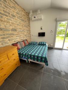 - une chambre avec un lit et un mur en briques dans l'établissement Domaine Ravy-Azalée, à Saint-Symphorien-sur-Saône