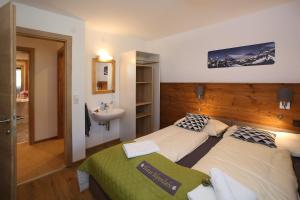 een hotelkamer met 2 bedden en een wastafel bij Haus Alpenliebe in Piesendorf