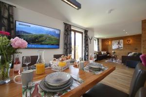 a living room with a table with a television on the wall at Haus Alpenliebe in Piesendorf
