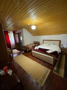 a bedroom with a large bed and a wooden ceiling at Guesthouse Mehmeti in Valbonë