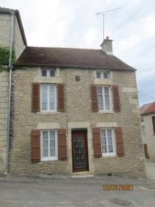 an old brick house with brown shutters on a street at GITE A SAINT-REMY (21500) in Saint-Rémy