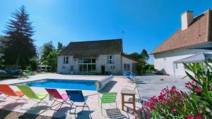 a swimming pool with chairs and a house at Domaine Ravy-Lilas in Saint-Symphorien-sur-Saône