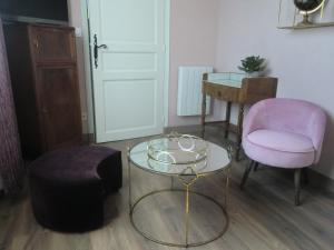 Cette chambre dispose d'une table en verre, d'une chaise et d'un tabouret. dans l'établissement Chambre d'hôtes LA BELLE SAISON, à Villedômer