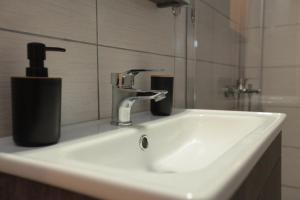 lavabo con dispensador de jabón en Apartment Chrisandro, en Nea Kalikratia 24 fotos más