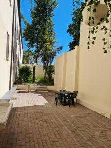 eine Terrasse mit einem Tisch und Bänken neben einem Gebäude in der Unterkunft Casa Santa Caterina e Sant Antonio in Padua