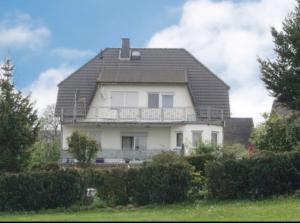 ein großes weißes Haus mit einem Gameradach in der Unterkunft Schöne große Ferienwohnung im Mittelrheintal nahe Loreley in Bornich