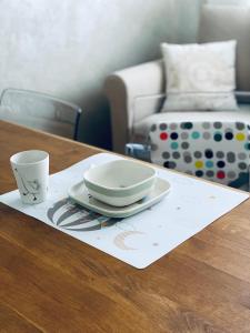 a table with two plates and a cup on a napkin at Boutique byt České Budějovice in České Budějovice