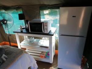un forno a microonde su un tavolo accanto a un frigorifero di Yebo Safaris, Glamping Adventures a Skukuza