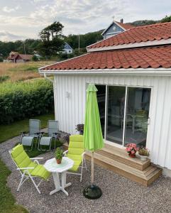 een patio met stoelen, een parasol en een tafel bij Nösund Guestroom in Nösund
