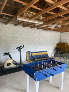 a room with a ping pong table and a treadmill at La Bienvenue in Tourtrol