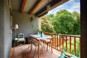 een veranda met een tafel en stoelen op een balkon bij Can Cruanyes in Sales del Llierca