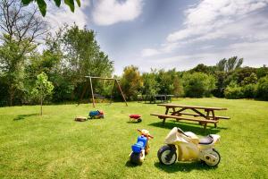 ein Spielzeug-Motorrad und ein Picknicktisch in einem Park in der Unterkunft Can Cruanyes in Sales del Llierca