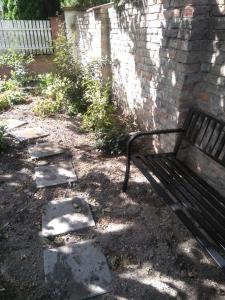a park bench sitting next to a brick wall at Čechovka in Břeclav