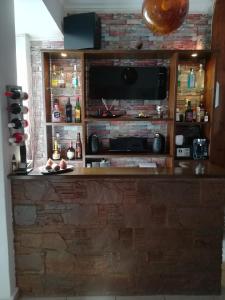 a entertainment center with a tv and a brick wall at Sitiahome in Sitia