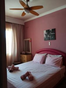 um quarto com uma cama grande e chinelos em Sitiahome em Sitia