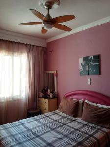 um quarto com uma cama e uma ventoinha de tecto em Sitiahome em Sitia