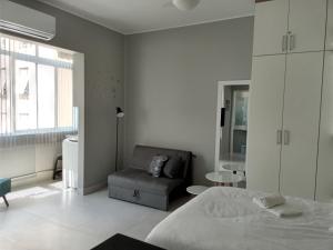 een slaapkamer met een bed, een stoel en een raam bij Charme da Bolivar in Rio de Janeiro +10 foto's