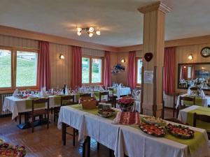 una sala da pranzo con tavoli e cibo di Hotel Zebrù a Valfurva