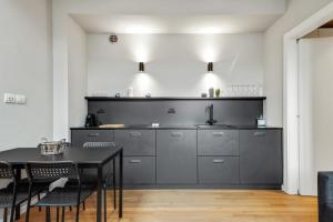 a kitchen with gray cabinets and a black table at Beautiful apartment in Chinatown and Sempione in Milan
