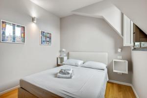a white bedroom with a bed and a staircase at Beautiful apartment in Chinatown and Sempione in Milan